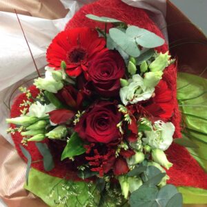 Bouquet toi et moi réalisé avec une base de 2 roses rouges et travail de fleurs et feuillages en harmonie